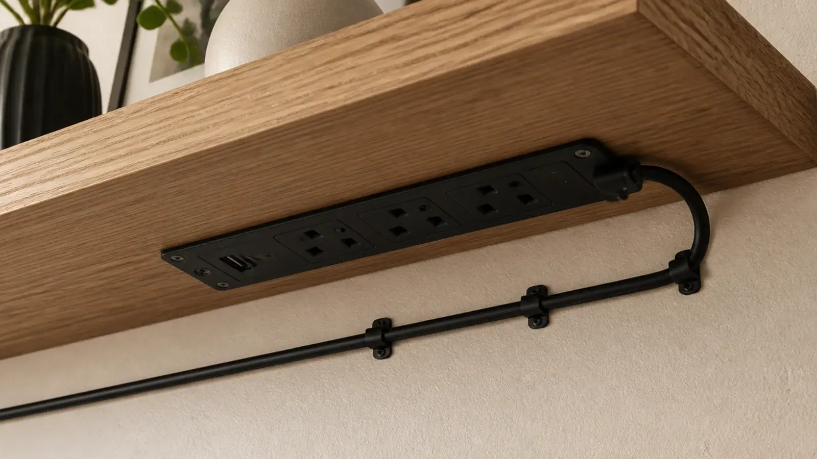 power strip strapped to the underside of a floating tv shelf