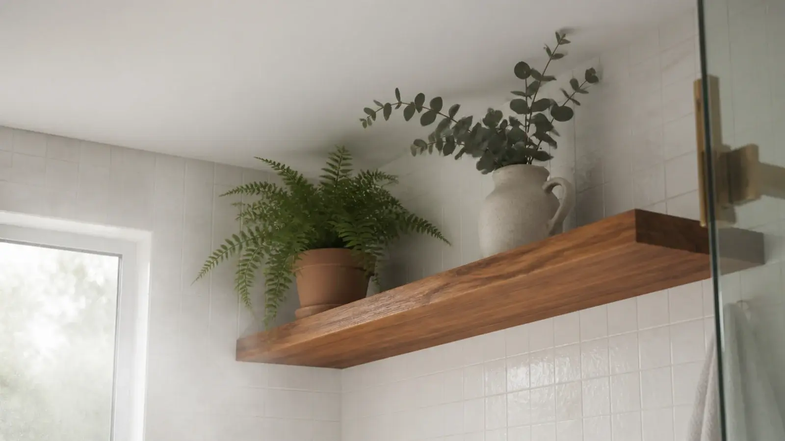 small fern and eucalyptus on a high floating shelf in a steamy bathroom