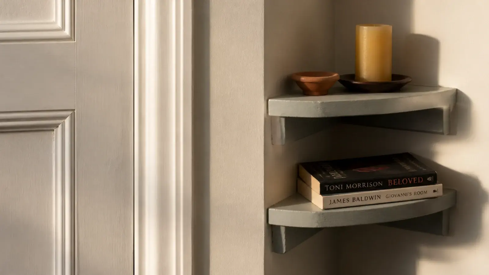 two short shelves fitted into a narrow wall strip beside a doorframe