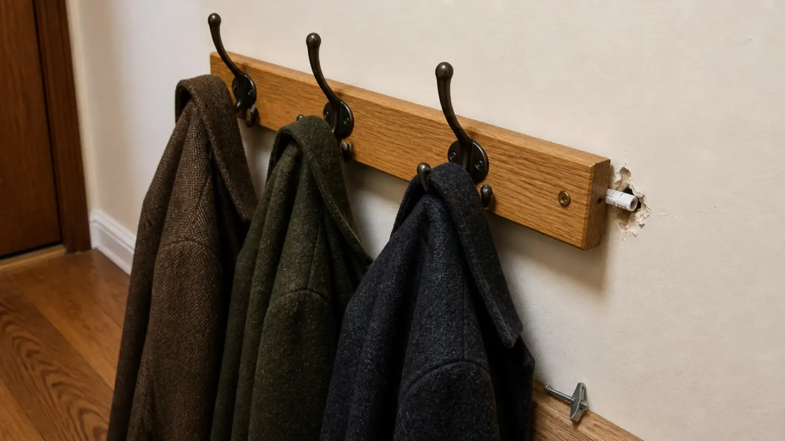 coat rail pulling loose from drywall under the weight of wet coats