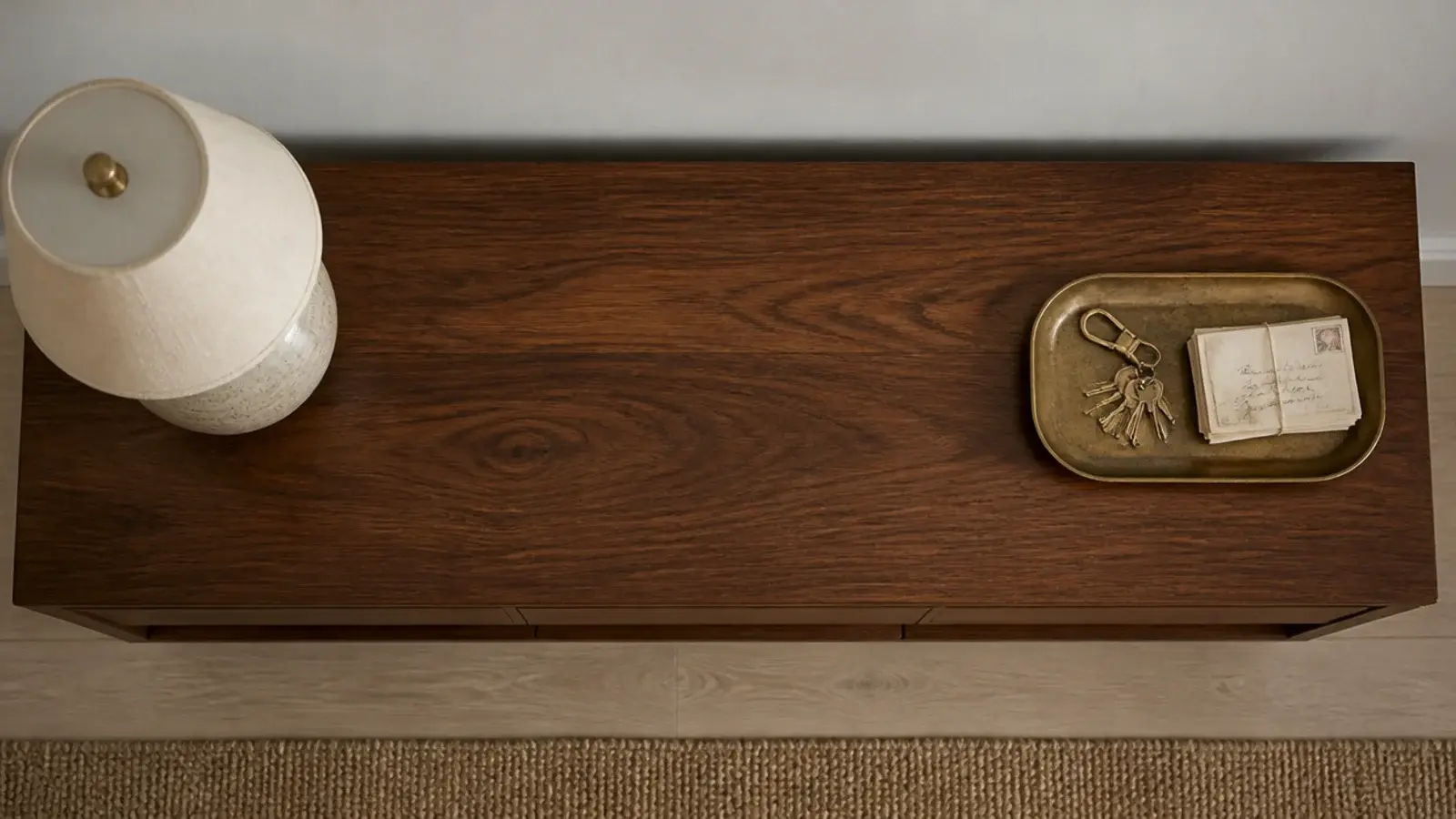 brass tray placed opposite the lamp on an entryway console top