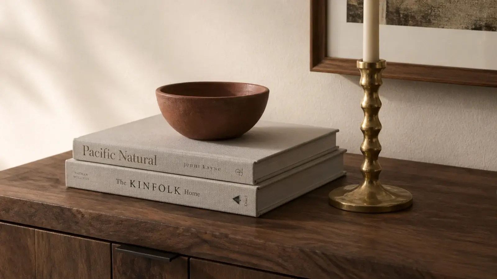 small clay bowl raised on two stacked books on an entry console