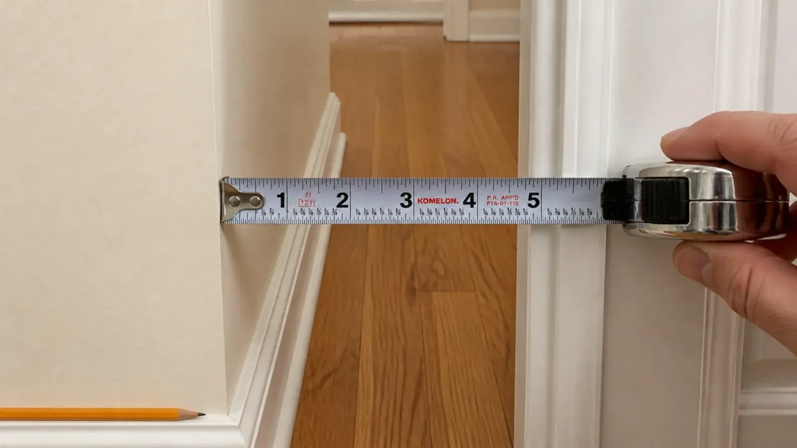 tape measure showing narrow clearance between an entry wall and doorframe