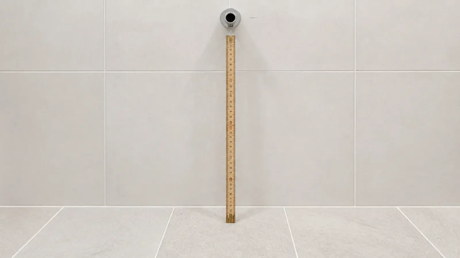 folding rule measuring the clear height in a small bathroom