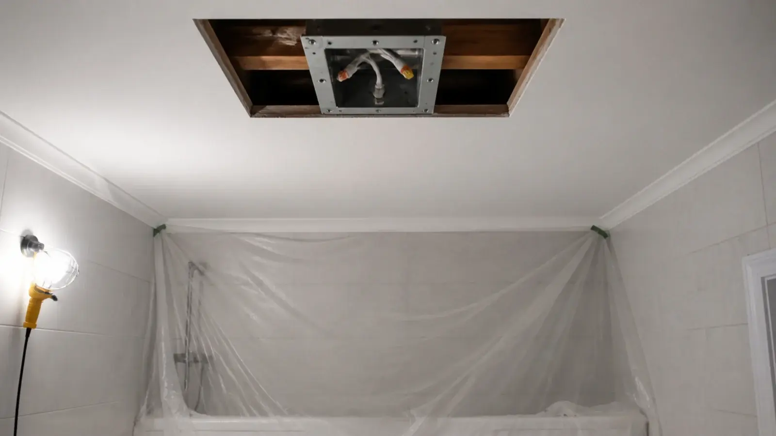 bathroom ceiling opened showing a mounting box fixed to timber