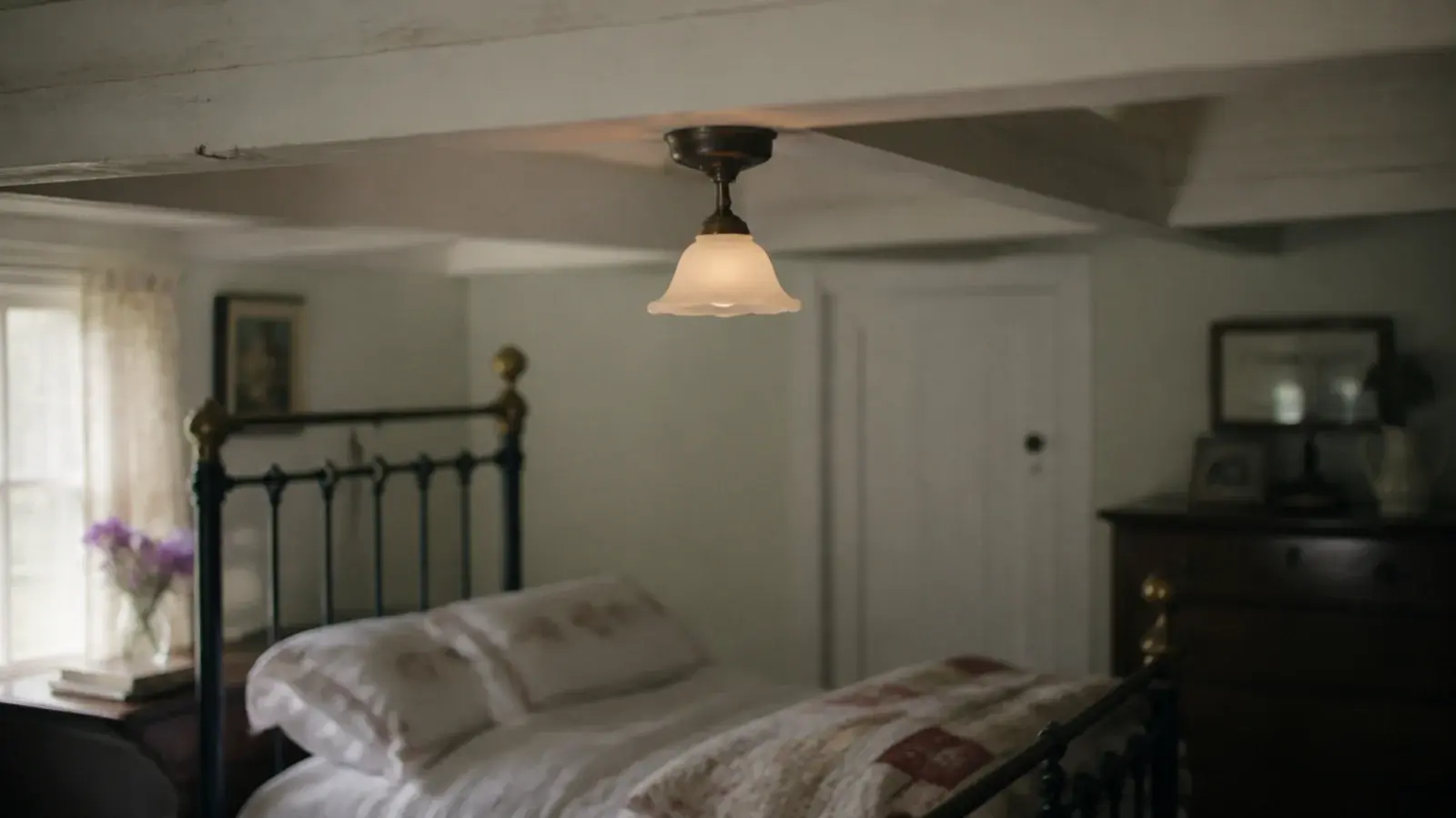 compact flush pendant hanging under a low bedroom ceiling beam
