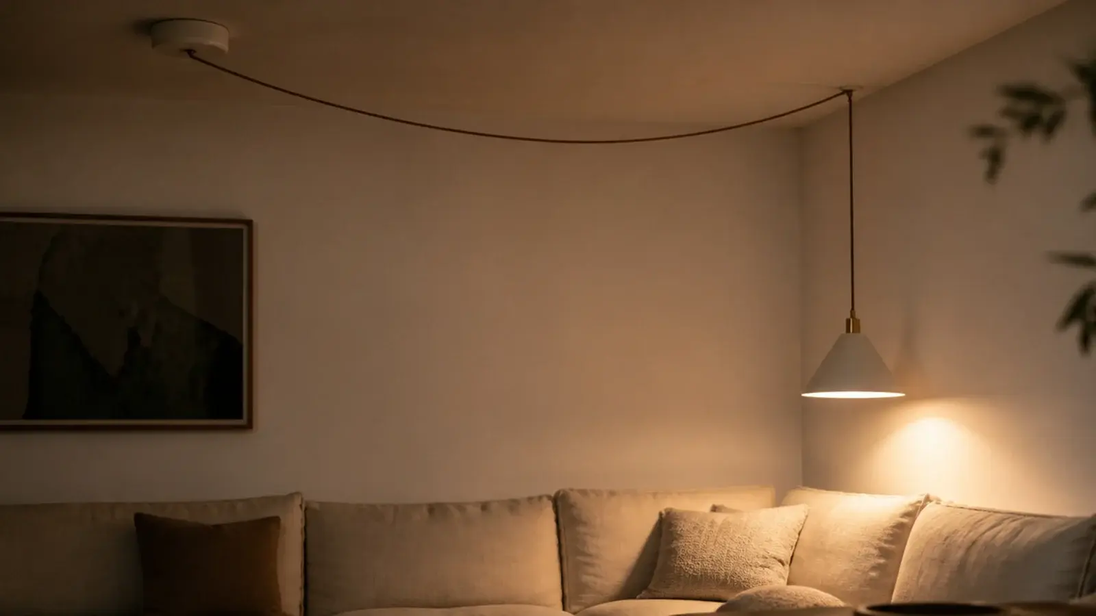 fabric cord swagged from a ceiling rose to a sofa corner