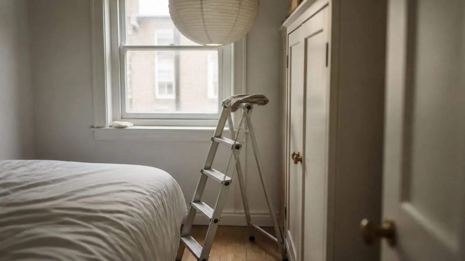 step ladder opened in a very small room beneath a pendant