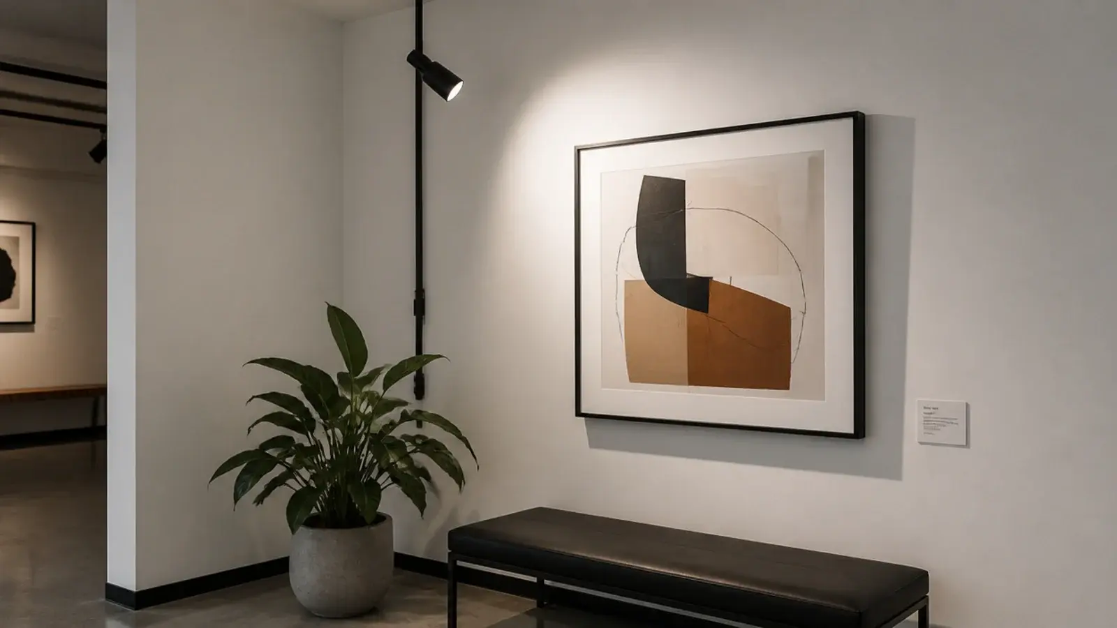 small adjustable spotlight hung on a rigid rod above artwork