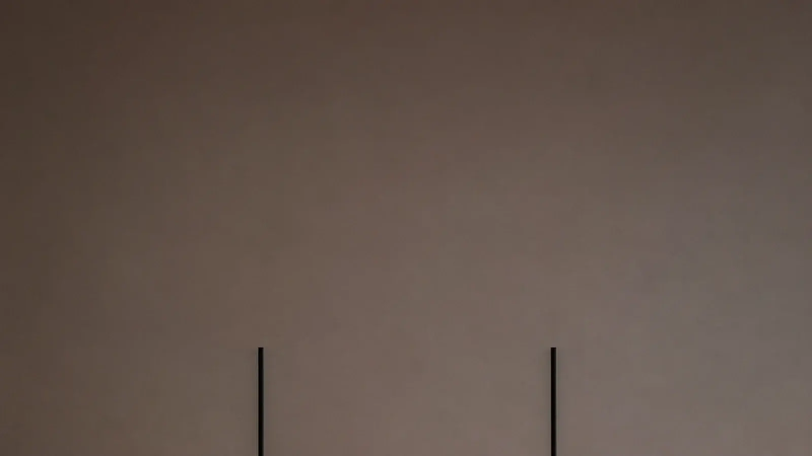 tall view of modern hanging lights glowing over a pale stone counter