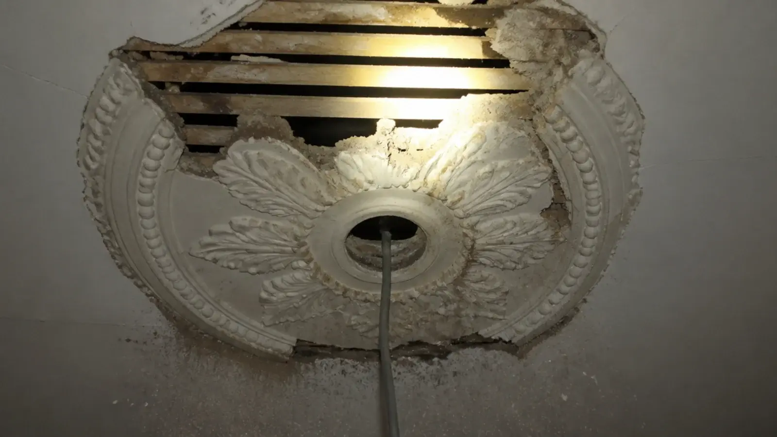 old plaster rose removed showing the fixing point behind it