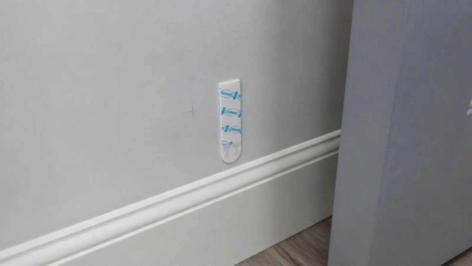 adhesive strip being tested on a hidden patch of rental paint