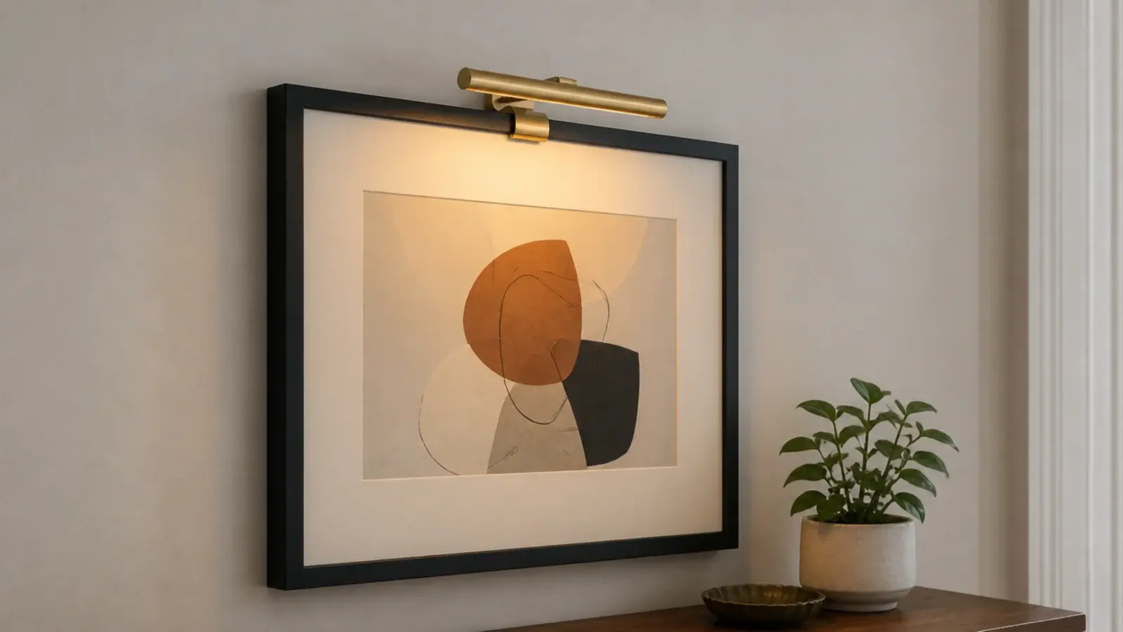 slim battery picture light clipped above a framed rental print
