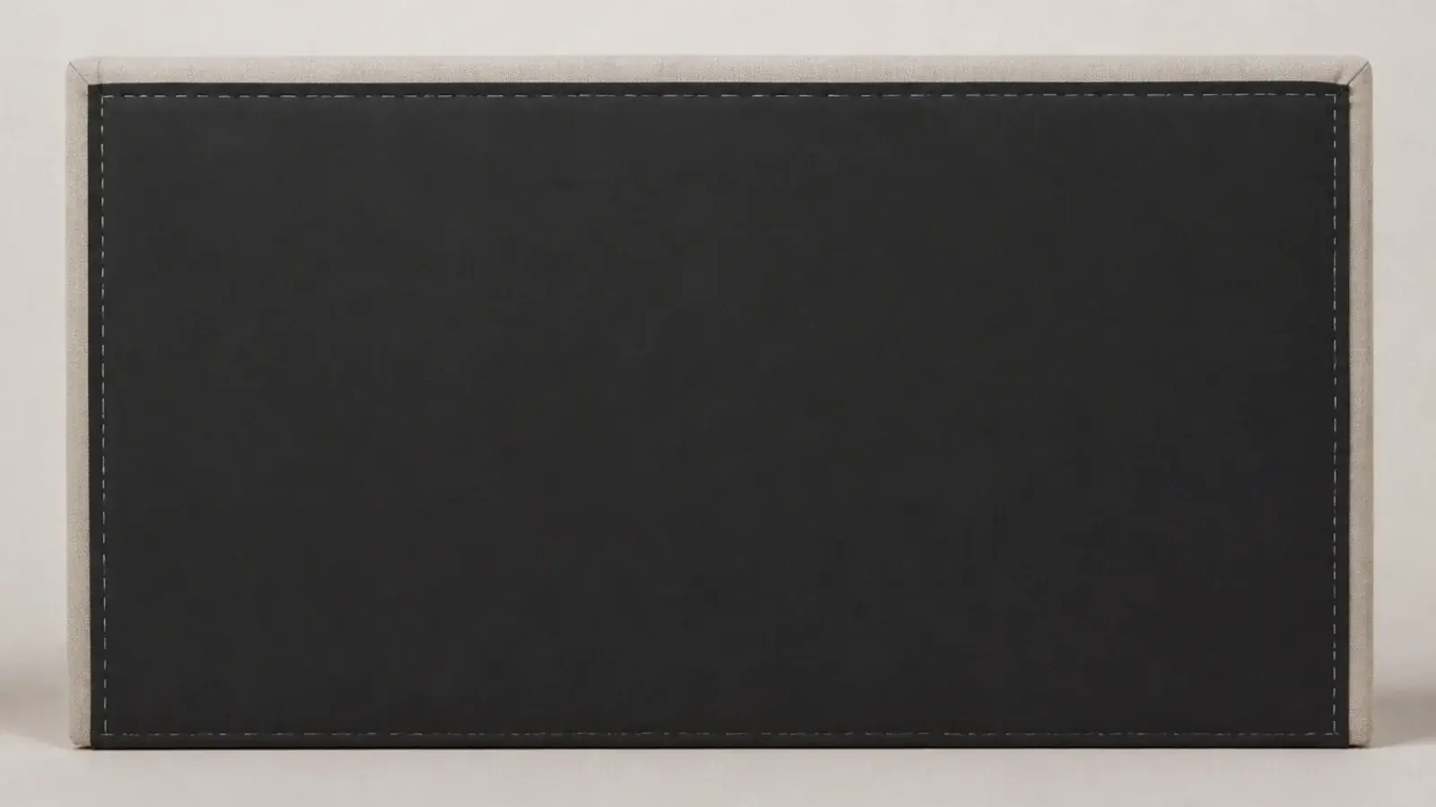 black cambric backing stapled across the rear of an upholstered headboard