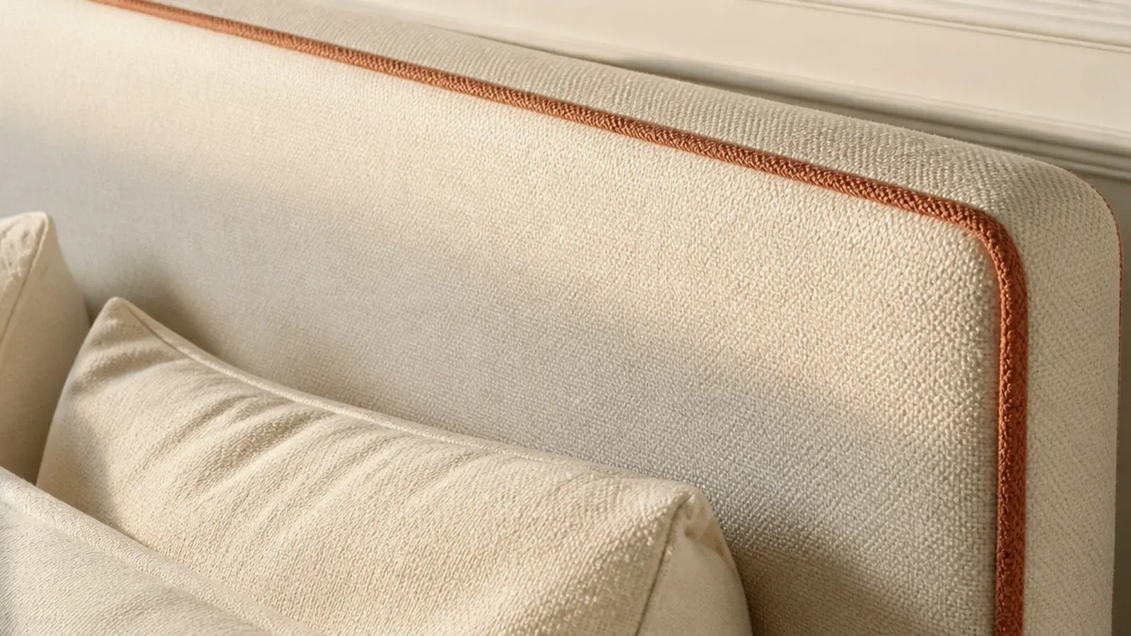 contrast tape trim running around the edge of a fabric headboard