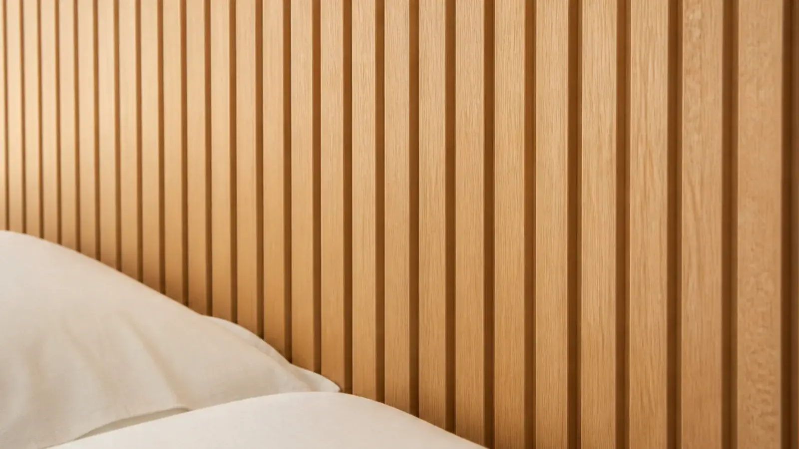 fluted oak headboard panel with even vertical grooves in warm timber