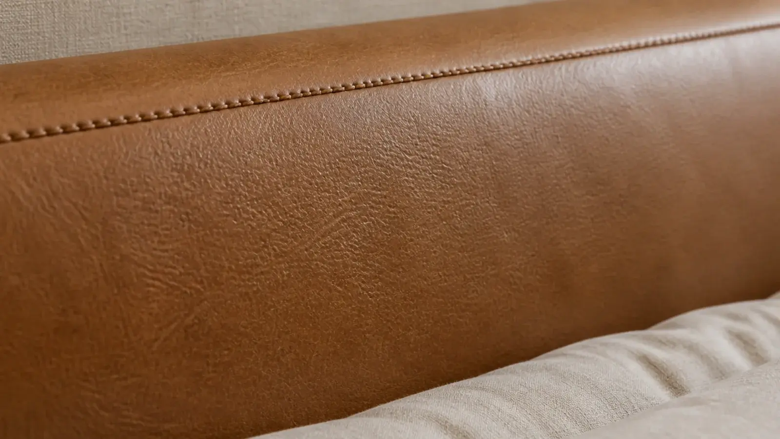 tan leather headboard panel with a single stitched seam along the top