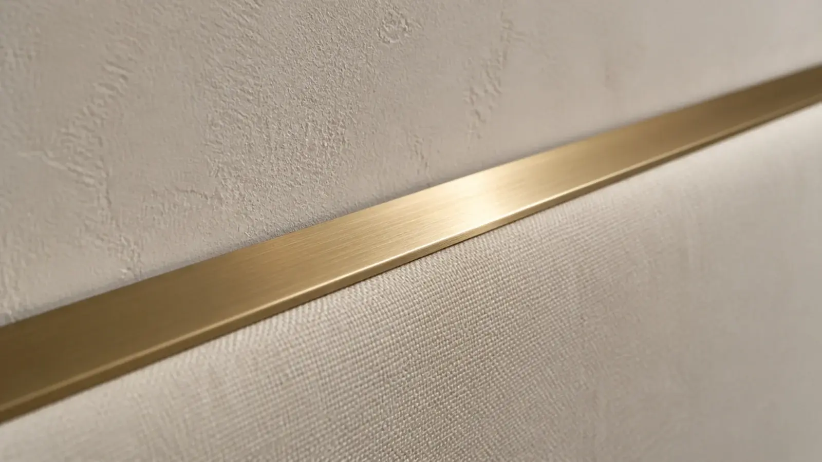 fine brass reveal strip running along the top edge of a fabric headboard