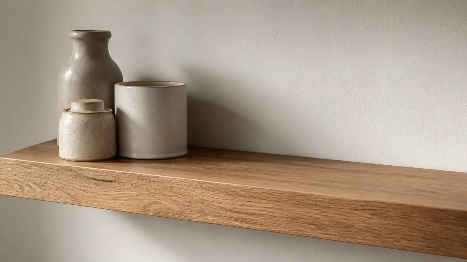 kitchen shelf with clear empty space beside a small group of stoneware
