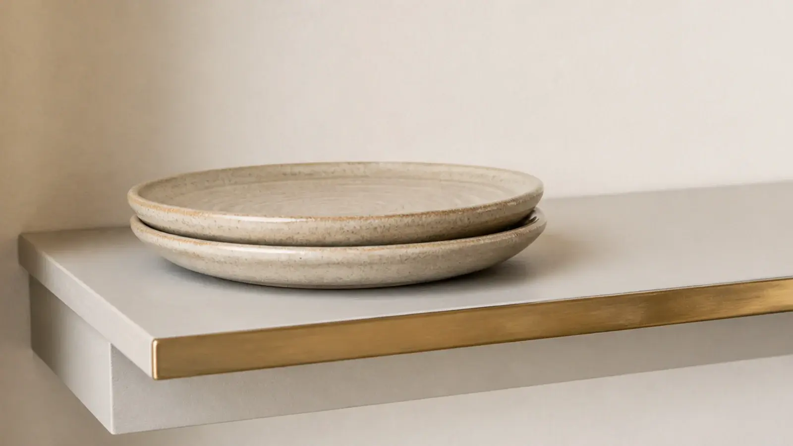 thin brass trim along the front edge of a pale modern kitchen shelf
