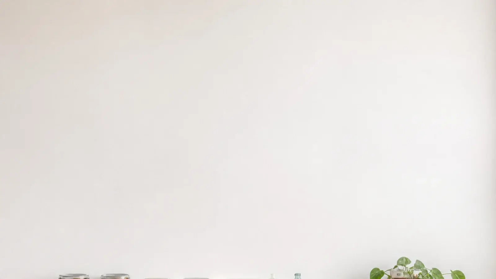 vertical image of budget open kitchen shelves with jars plates and a plant