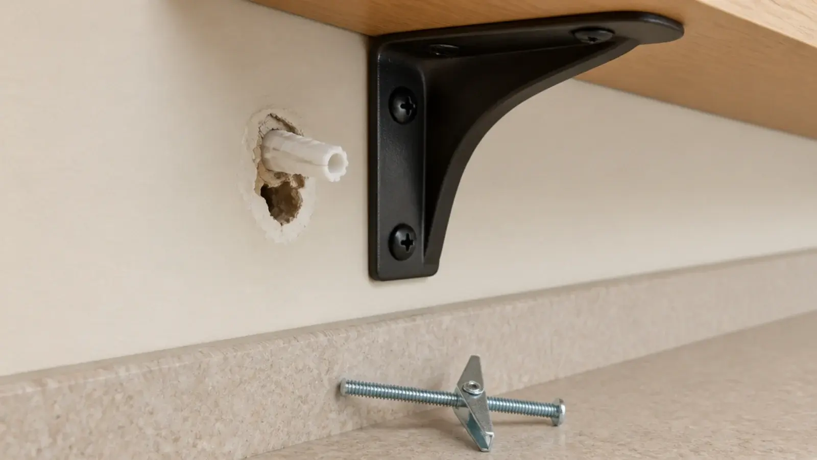 plastic wall plug pulled loose from drywall beneath a kitchen shelf bracket