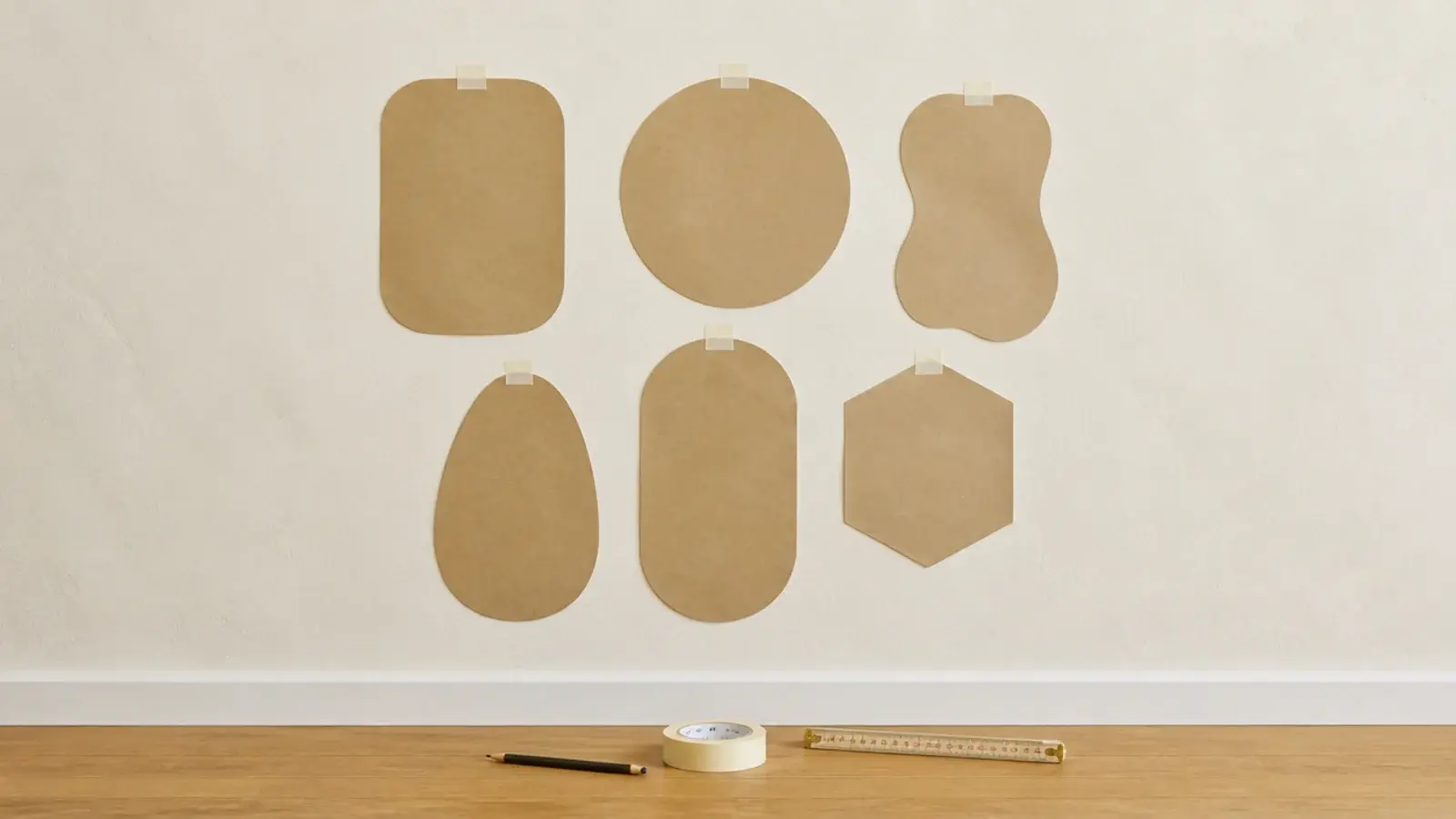 paper templates for small mirrors taped across a blank cream wall