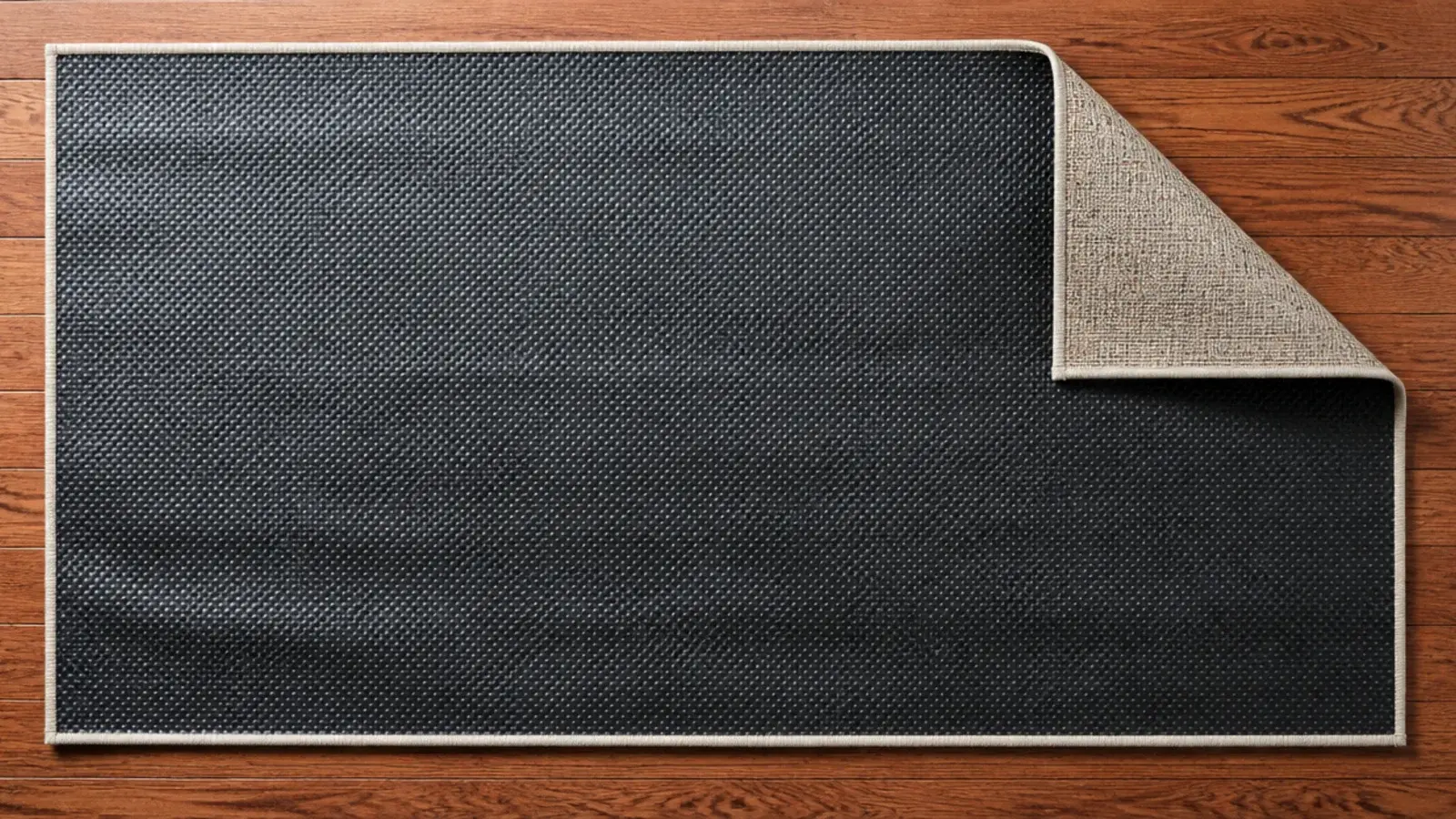 underside of a rug showing a stiff rubberised adhesive backing