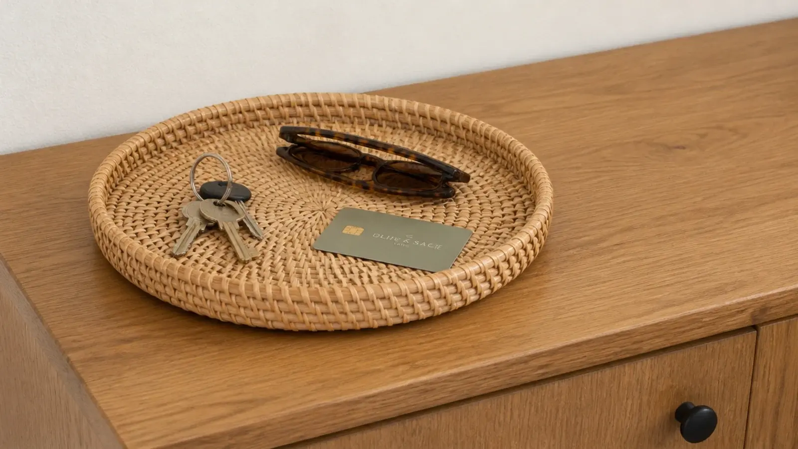 rattan tray containing keys and cards on a clear shoe cabinet top