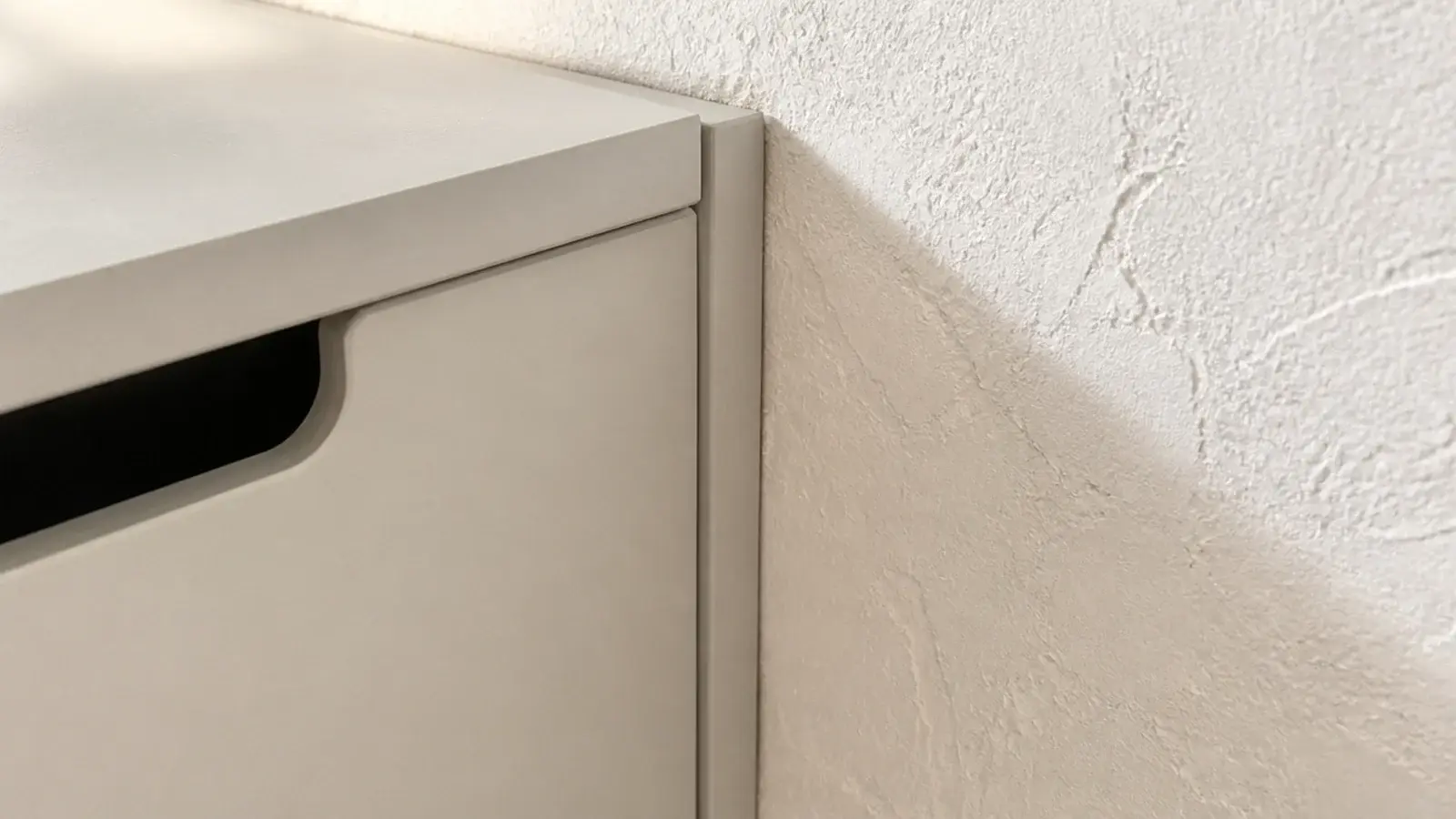 scribe trim closing the tapering gap beside a hallway shoe cabinet