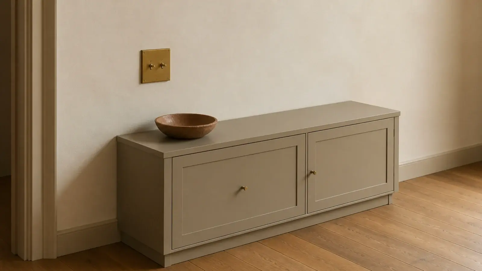 shoe cabinet top ending just below a hallway light switch plate