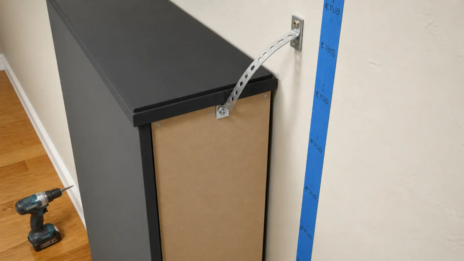 anti tip strap fixing a shoe cabinet to the wall of a small entryway