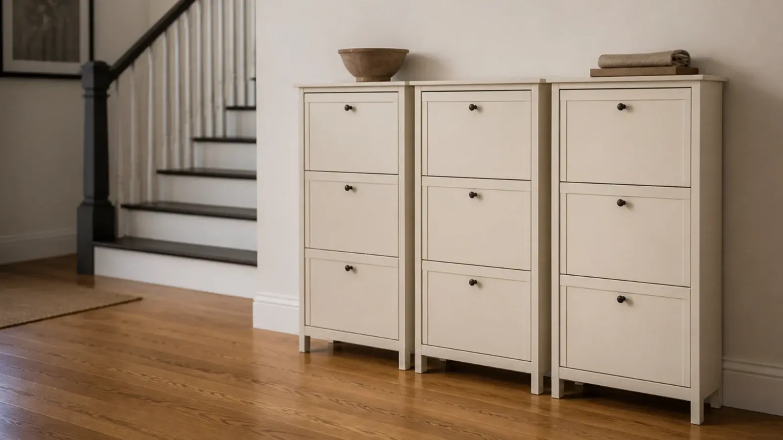 row of slim tilt out shoe cabinets along a wall beside a staircase