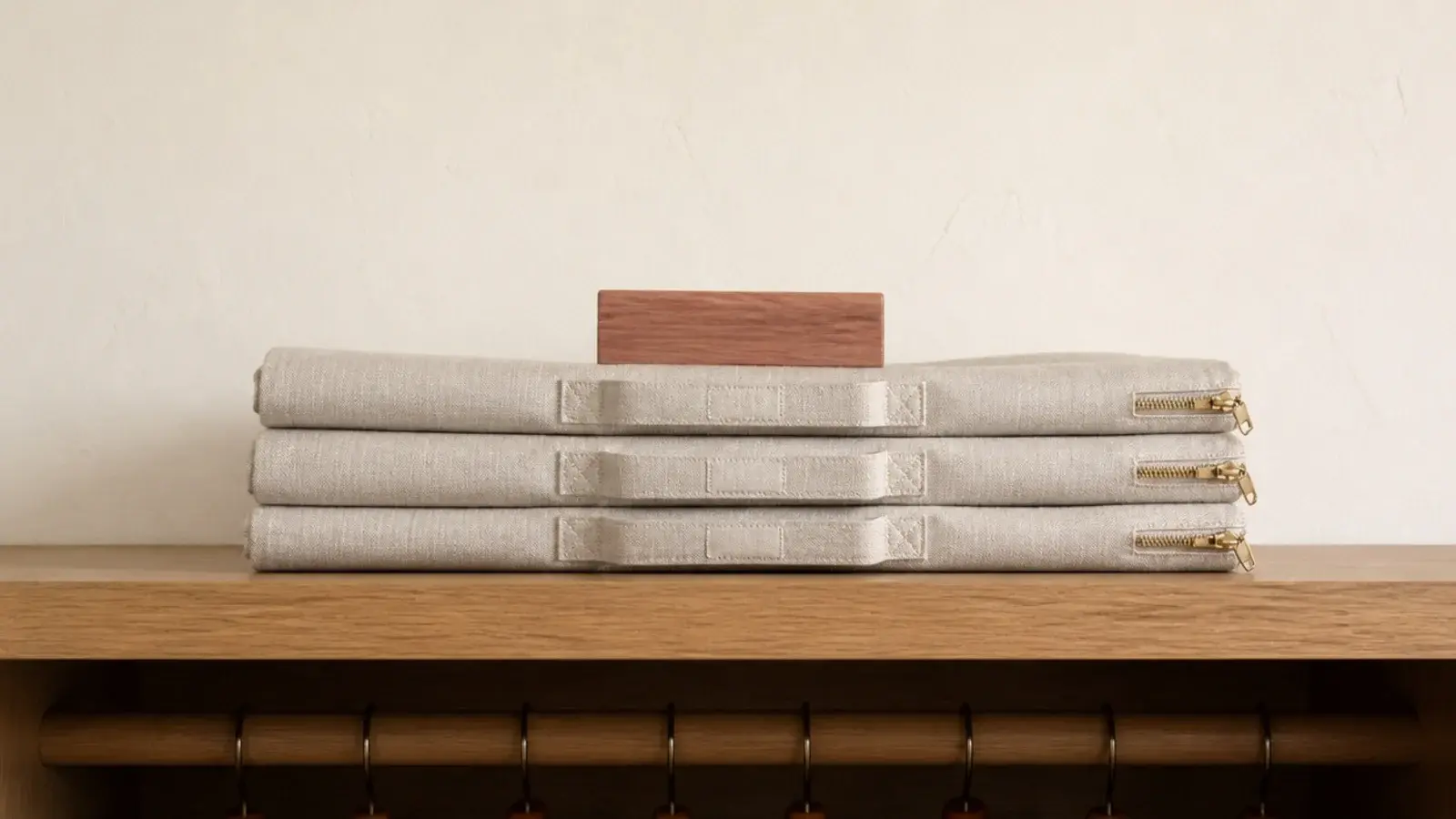 natural linen garment bags stored on a high closet shelf