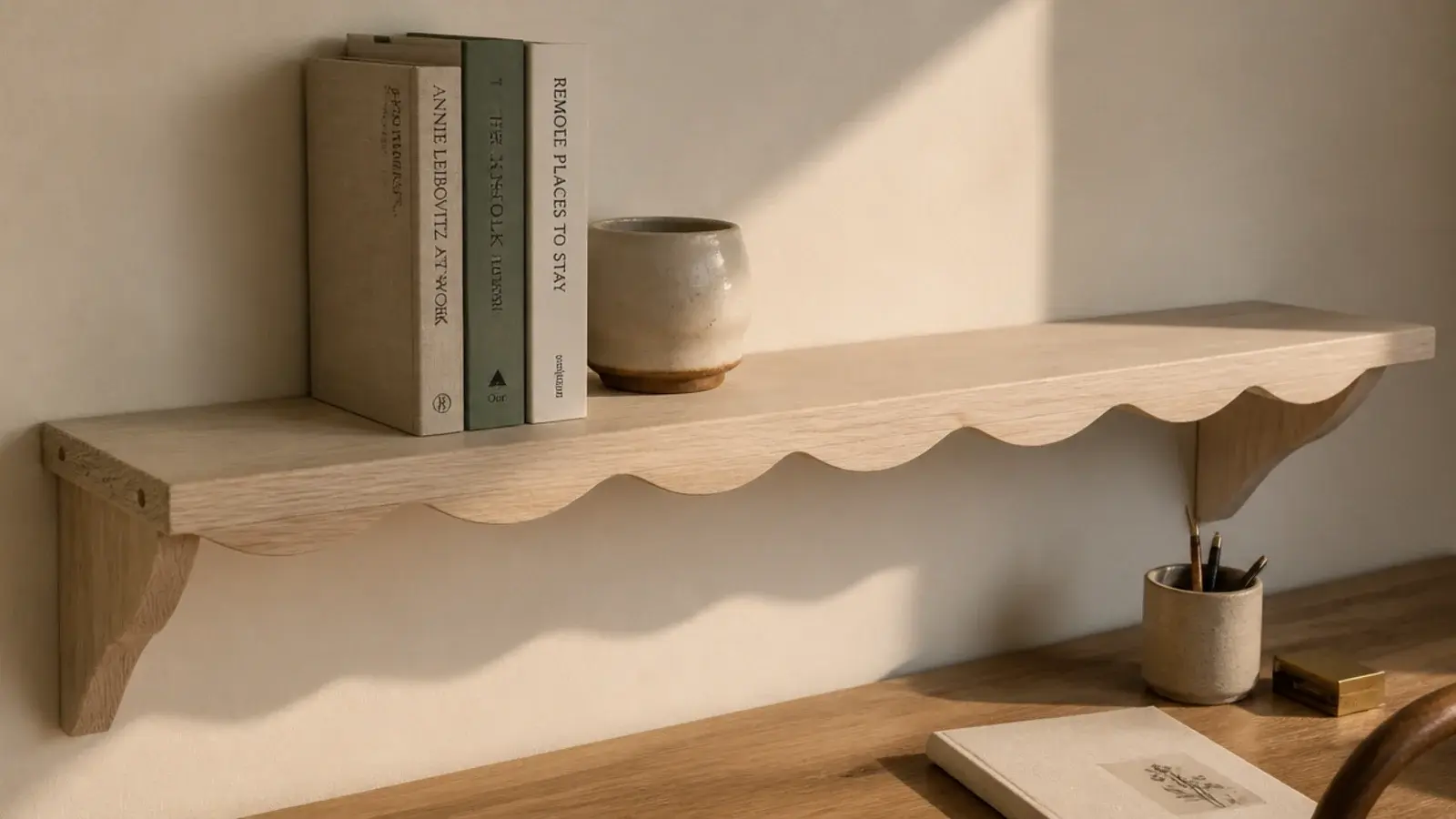 shelf with a scalloped front edge above a small study desk