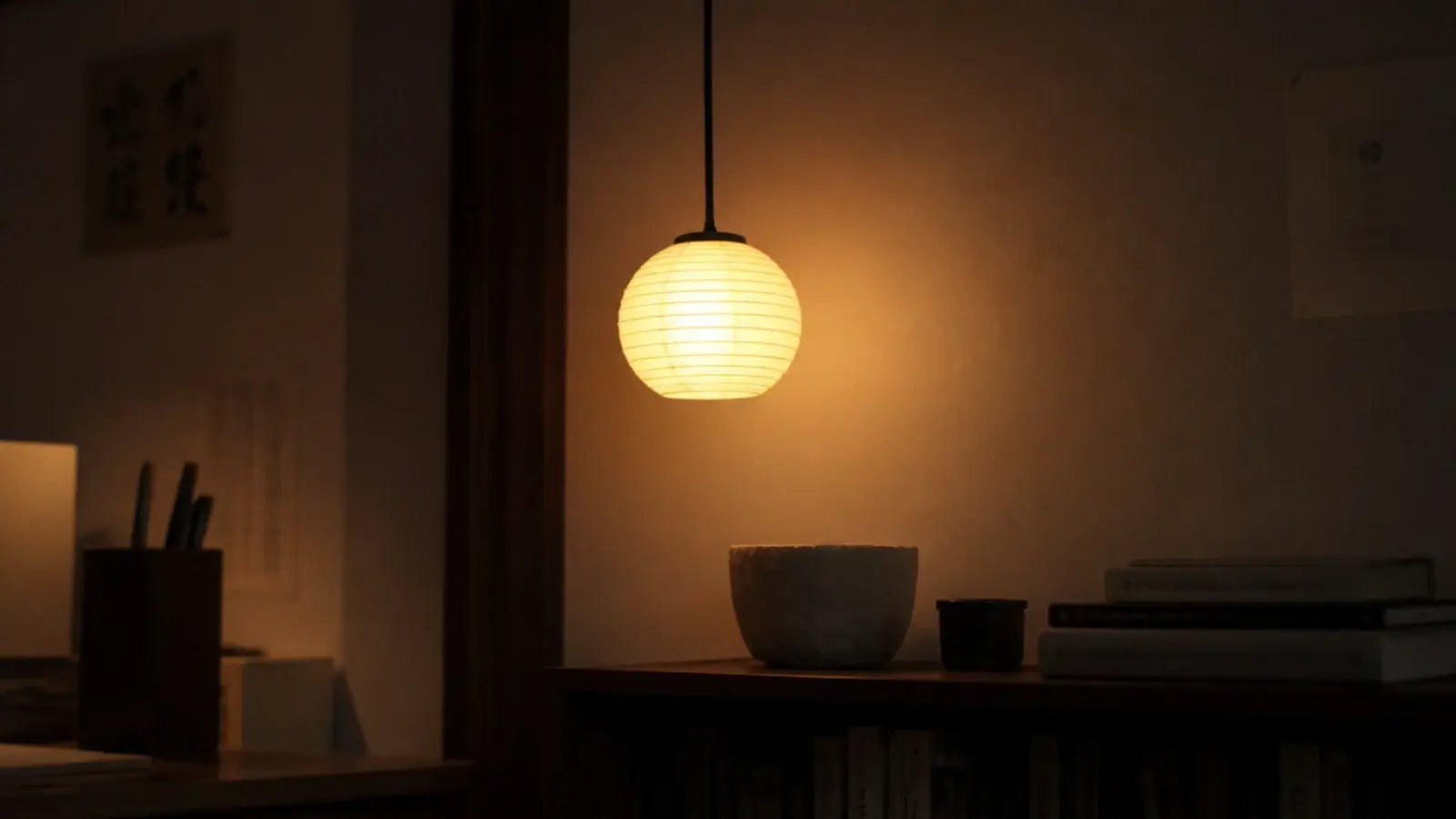 small paper lantern hanging above a shelf beside a study desk
