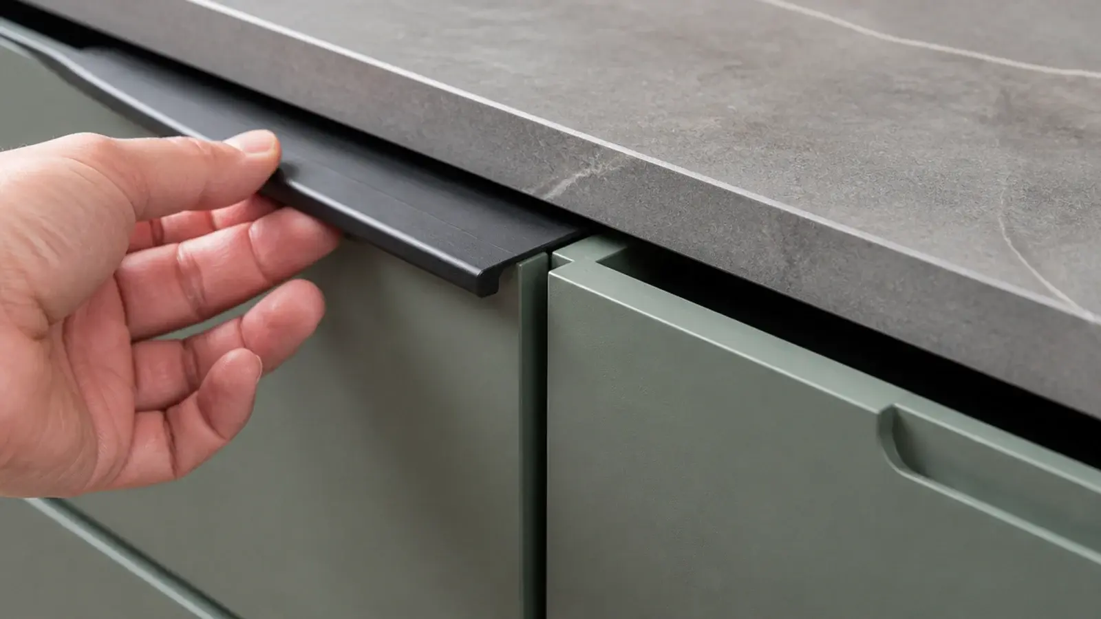slim recessed edge pull along the top of a painted drawer front