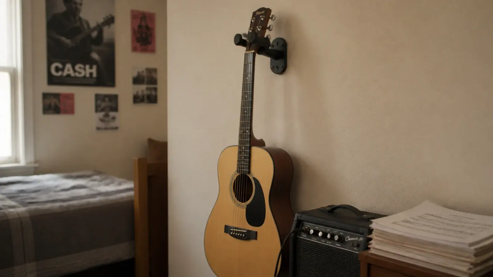 acoustic guitar hung on a wall bracket beside a small amplifier