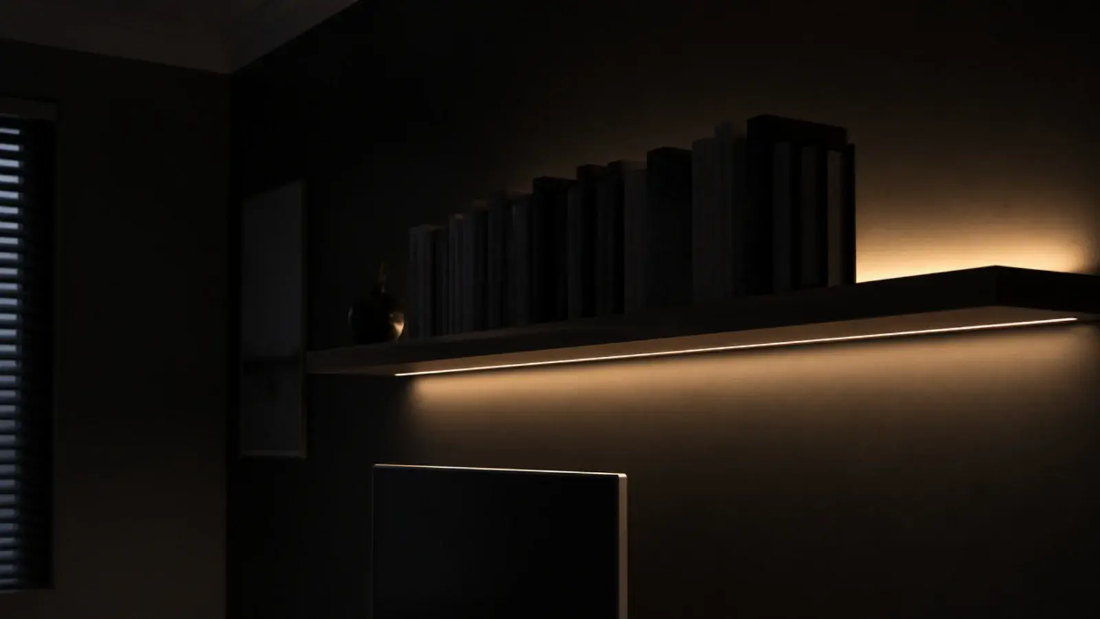 single hidden light strip glowing behind a shelf on a dark wall