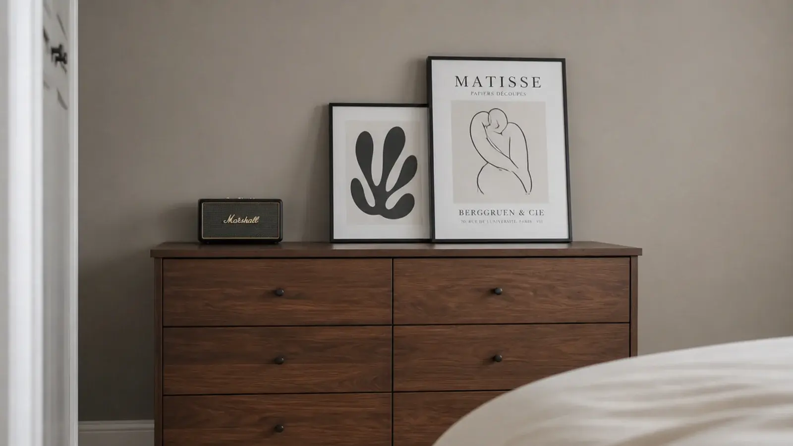 mushroom taupe wall behind a chest of drawers and framed prints