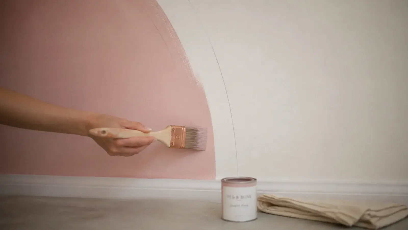 half painted wall arch in dusty pink with brush and tester pot below