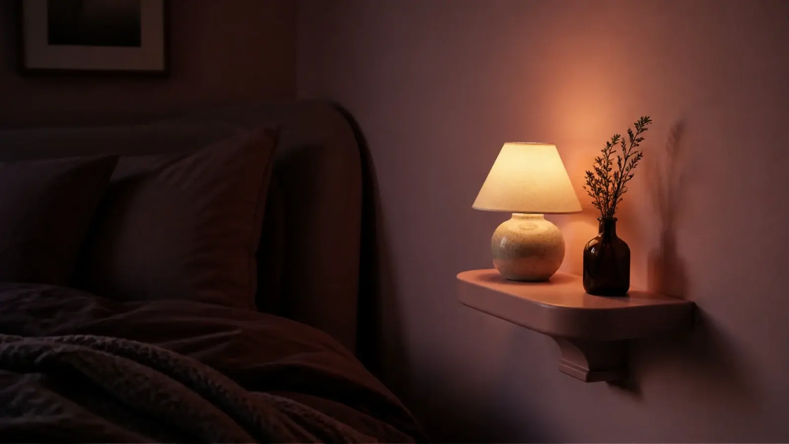 warm bulb lamp glowing against pink walls in an evening bedroom