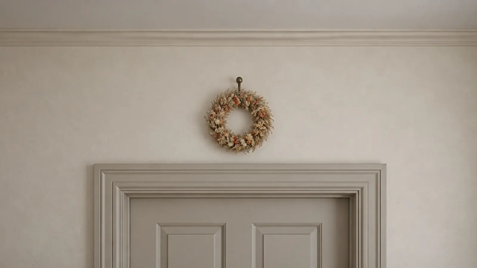 small dried flower wreath hanging high above a bedroom doorway