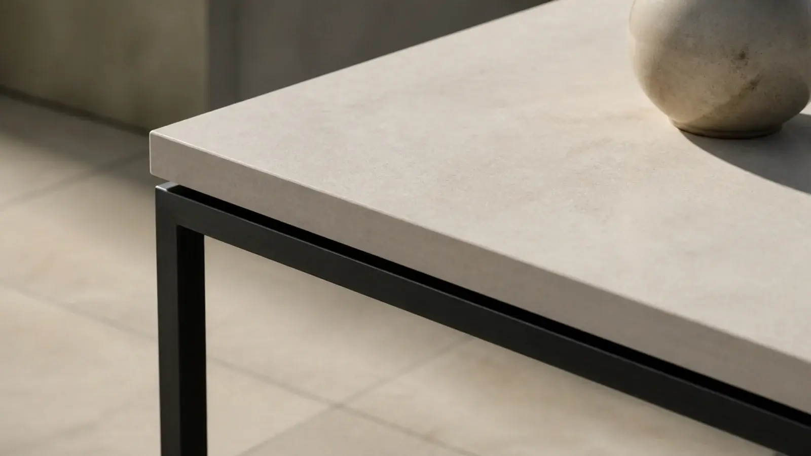 pale stone slab top resting on a fine blackened steel media base