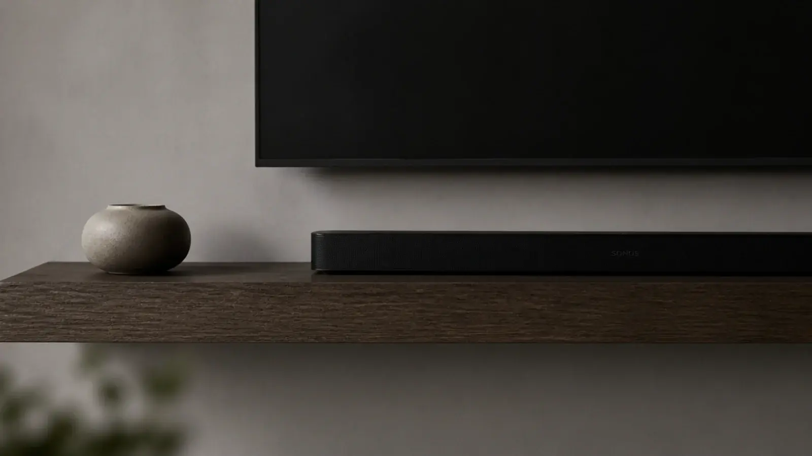 one long floating shelf under a screen with two objects on it