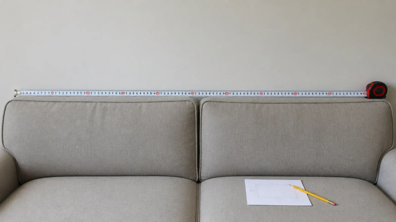 tape measure held across the back of a sofa to set art width