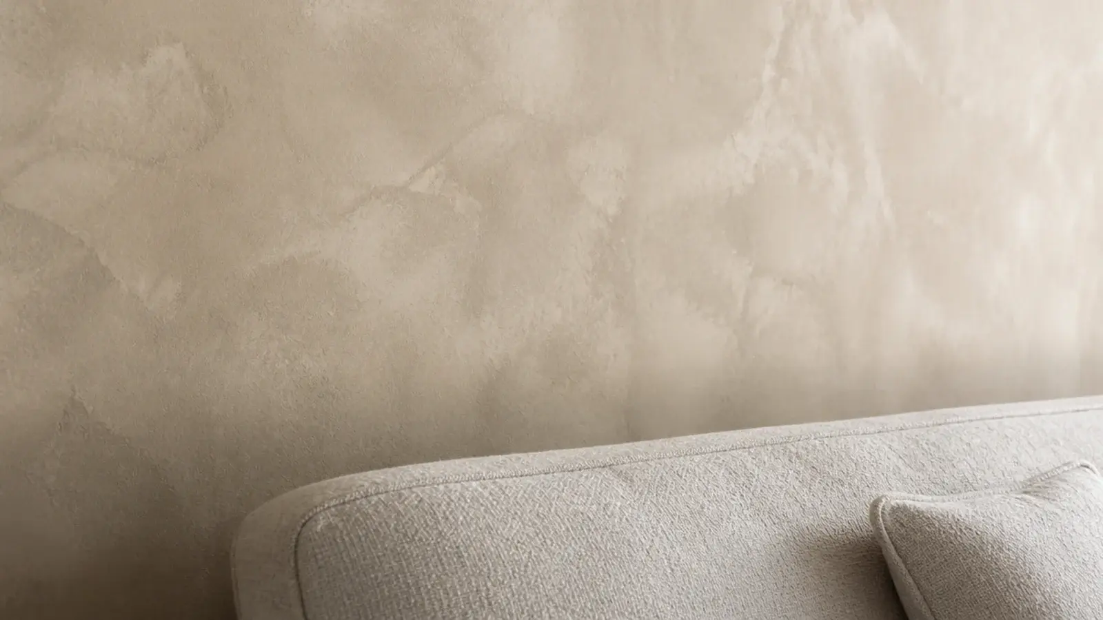 limewashed wall behind a sofa with a sealed matt surface