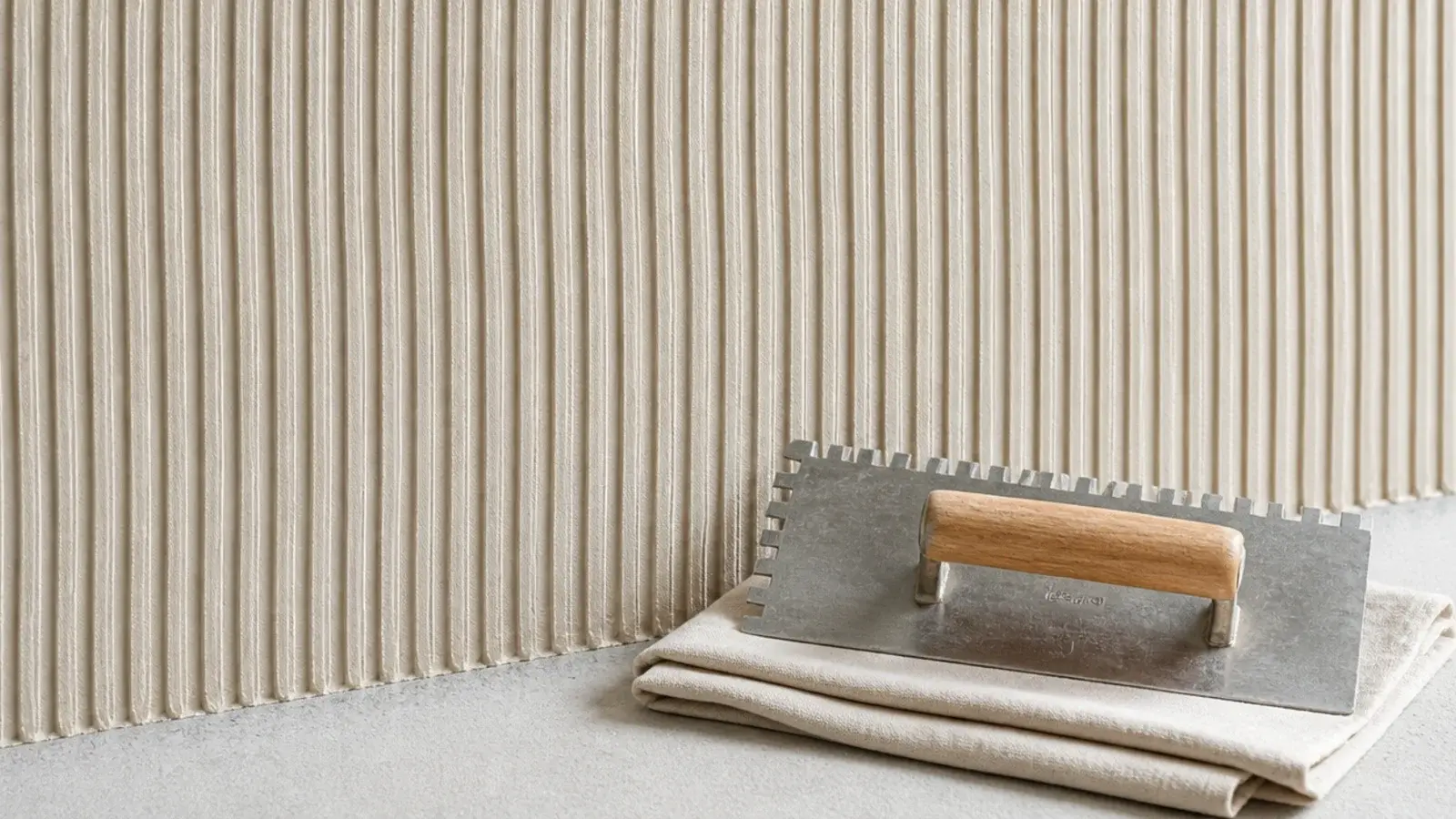 combed plaster wall showing regular parallel grooves across the face