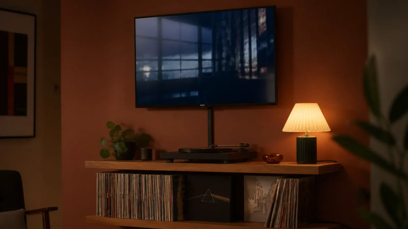 screen mounted on a bracket directly above two open timber shelves