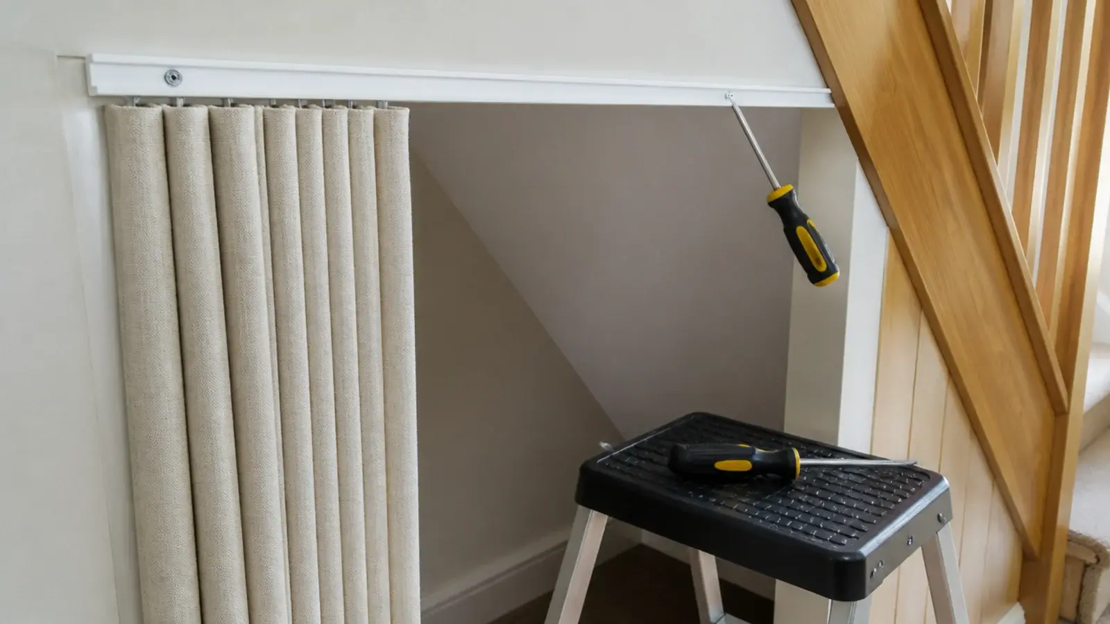 slim ceiling track being screwed across an under stairs opening
